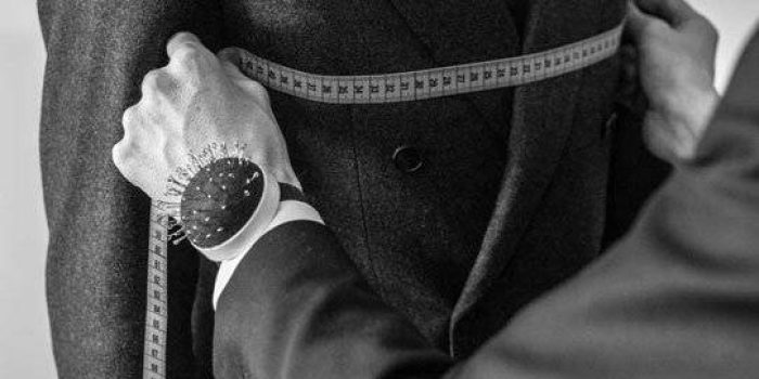 Professioneller Schneider bei der Maßnahme an einem zweibrüstigen Maßjackett im Monokel Store Riga